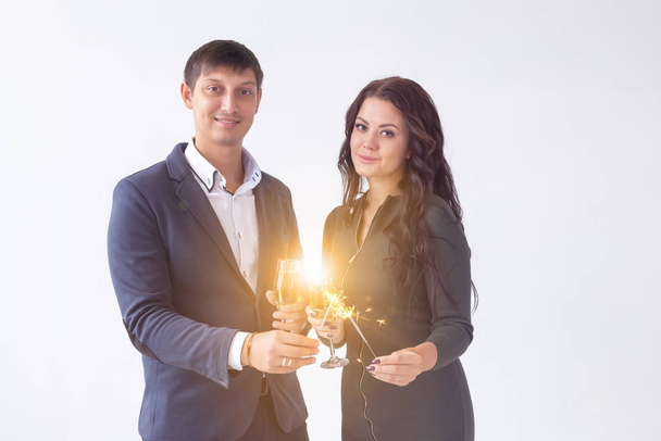 Valentines day and date concept - Couple with champagne glasses and sparklers on white background - Foto, afbeelding
