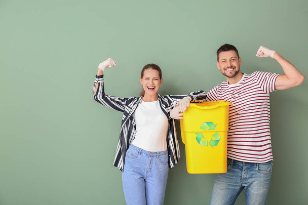 Couple with container for garbage on color background. Concept of recycling - Photo, Image
