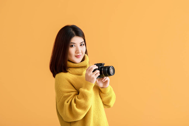 Beautiful Asian photographer on color background - Φωτογραφία, εικόνα