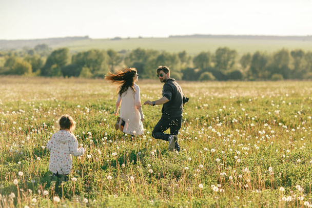 Щасливий батько сім'ї, мати і дочка на природі на заході сонця
 - Фото, зображення