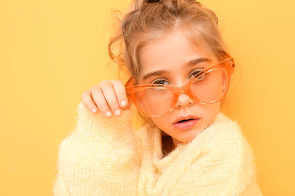 Cute fashionable girl with sunglasses on color background - Фото, изображение