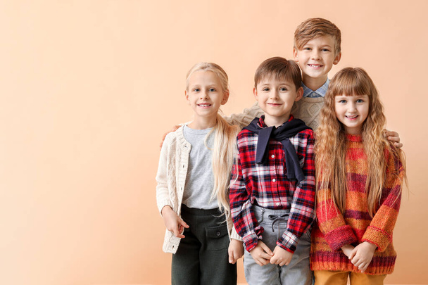 Милі маленькі діти в осінньому одязі біля кольорової стіни
 - Фото, зображення
