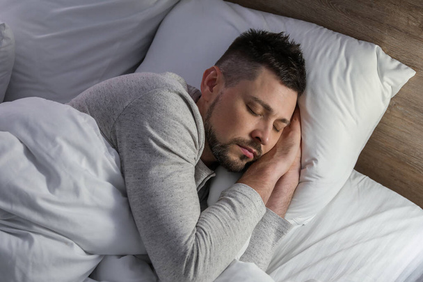 Hezký muž spí v posteli v noci - Fotografie, Obrázek