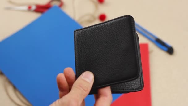human hand puts two paper heart red and blue into black leather wallet, concept of valentine gift surprise or lucky talisman or happy romantic love, close-up   - Footage, Video