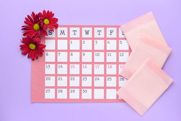 Menstrual calendar with pads on color background - Photo, Image