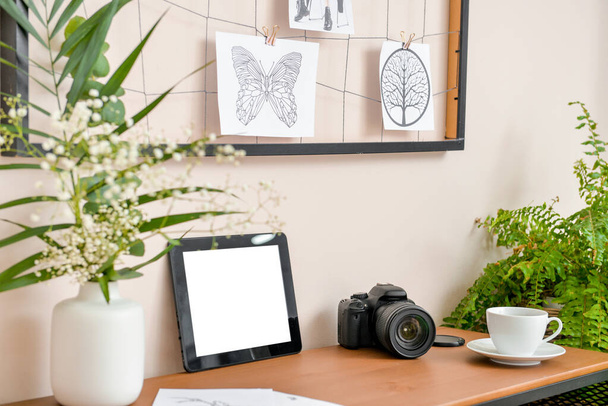 Elegante lugar de trabajo cómodo con tableta PC, moodboard y cámara de fotos en la habitación moderna
 - Foto, Imagen