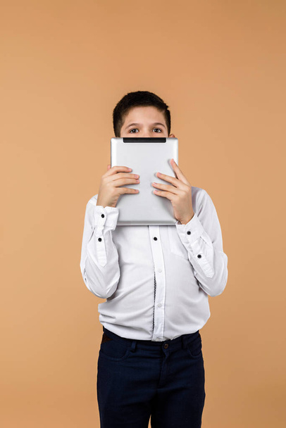 Emotional schoolboy holding digital tablet - Photo, Image