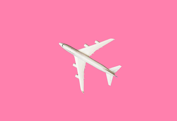 Modelo plano, avión sobre fondo de color pastel rosa con espacio de copia.Diseño plano de laice.Concepto de viaje sobre fondo rosa. plano modelo vista superior sobre fondo de color rosa
. - Foto, imagen