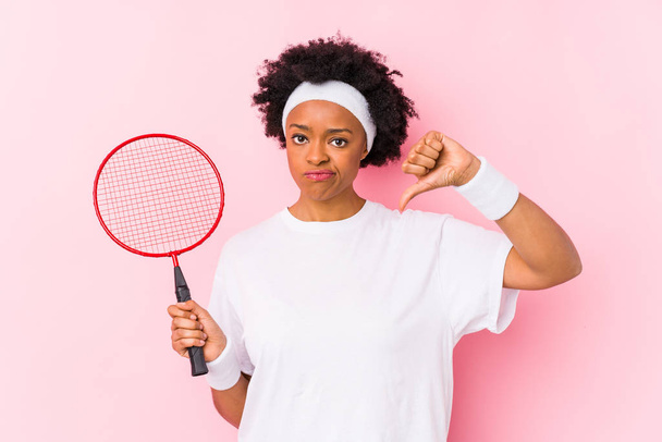 Giovane donna afroamericana che gioca a badminton isolata mostrando un gesto antipatico, pollice in giu '. Concetto di disaccordo
. - Foto, immagini