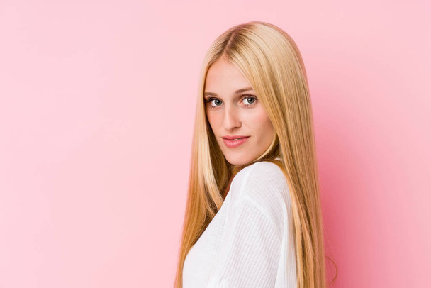 Young blonde woman face closeup isolated on a pink background - Φωτογραφία, εικόνα