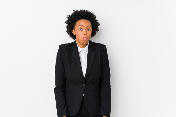 中年アフリカ系アメリカ人のビジネス女性に対して白い背景孤立したshrugs肩とオープン目混乱. - 写真・画像