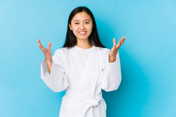 fiatal kínai nő gyakorló karate elszigetelt kap egy kellemes meglepetés, izgatott és felemeli a kezét. - Fotó, kép