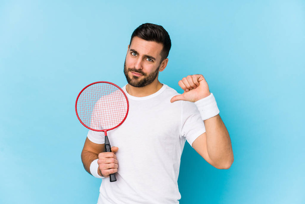 junger gutaussehender Mann spielt Badminton isoliert fühlt sich stolz und selbstbewusst, Beispiel zu folgen. - Foto, Bild