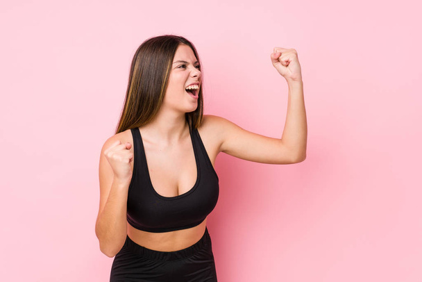 Jovem mulher caucasiana fitness isolado levantando punho após uma vitória, conceito vencedor
. - Foto, Imagem
