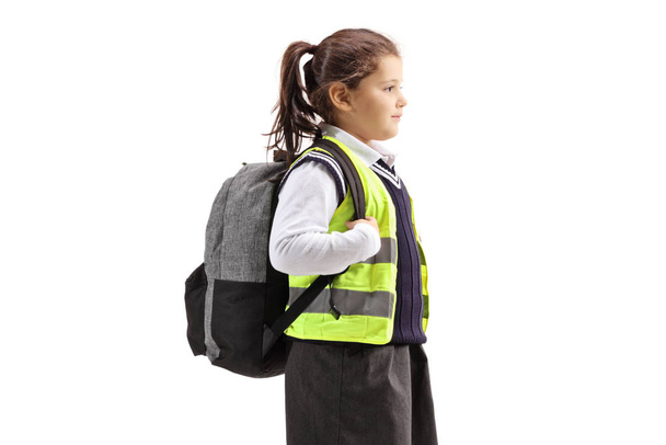 Schoolgirl with a backpack wearing safety vest - 写真・画像