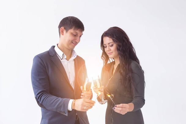 Valentines day and date concept - Couple with champagne glasses and sparklers on white background - Foto, Imagem
