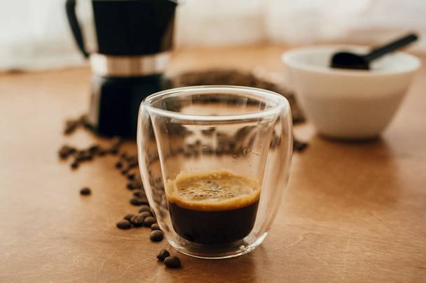 Espresso lasikupissa, paahdetut kahvipavut, maadoitettu kahvi
 - Valokuva, kuva