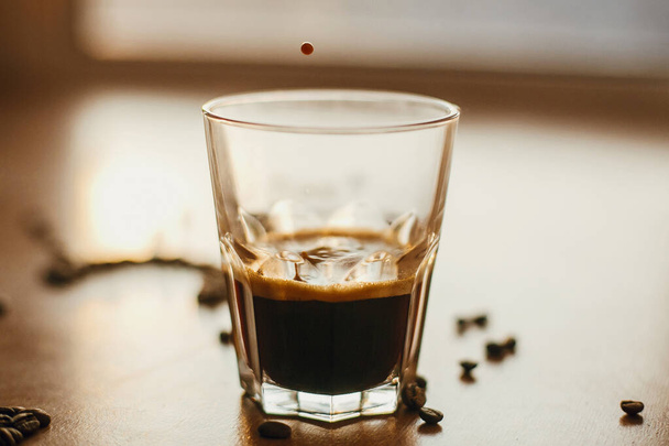 Gocce di caffè ravvicinate in luce calda mentre versano espresso caldo i
 - Foto, immagini