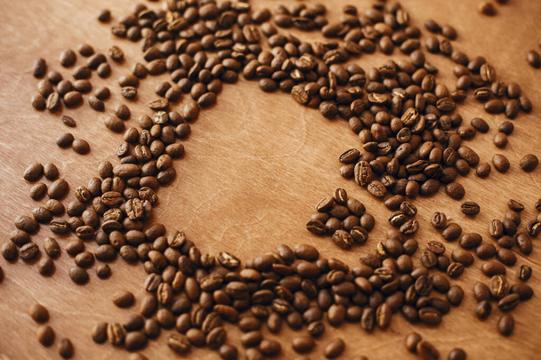 Forma tazzina da caffè realizzata in chicchi di caffè tostati su tavolo in legno. Io...
 - Foto, immagini