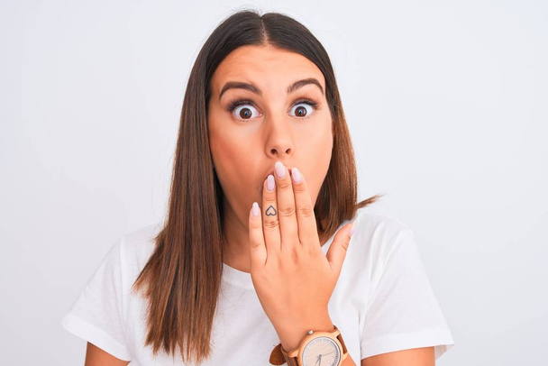 Close up of beautiful and young brunette woman standing over isolated white background cover mouth with hand shocked with shame for mistake, expression of fear, scared in silence, secret concept - Φωτογραφία, εικόνα