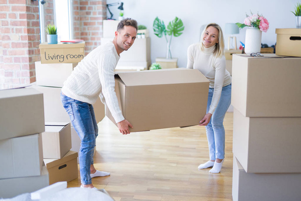 Jovem casal bonito em movimento caixas de papelão em nova casa
 - Foto, Imagem