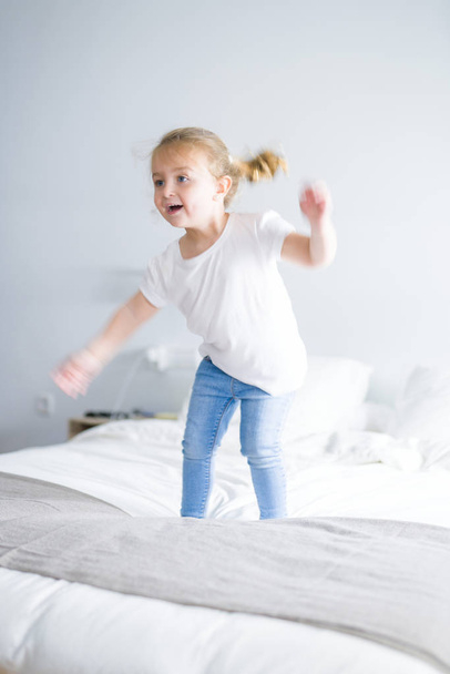 Güzel. yatakta atlama yürümeye başlayan çocuk kız - Fotoğraf, Görsel