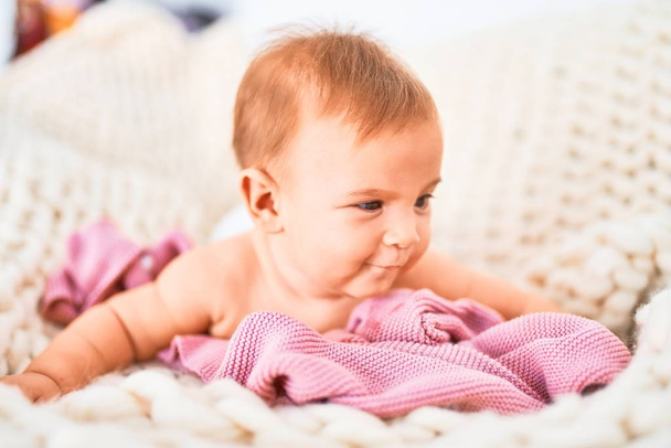 Evdeki kanepede battaniyenin üzerine uzanmış sevimli bir bebek. Yeni doğmuş bebek rahatlıyor ve dinleniyor. - Fotoğraf, Görsel