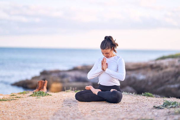 junge schöne Sportlerin praktiziert Yoga. Trainer lehrt Gebetspose am Strand - Foto, Bild