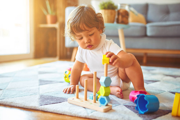 schöne Kleinkind Kind Mädchen spielt mit Spielzeug auf dem Teppich - Foto, Bild