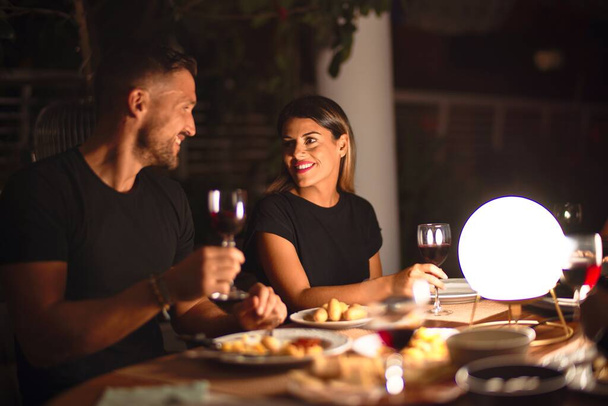 Jeune beau couple dînant sur la célébration toasting et souriant sur la terrasse
 - Photo, image
