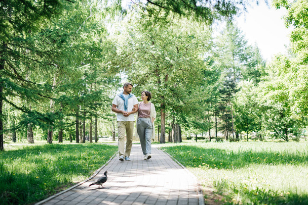Middle-aged couple walking in the park together at the weekend. - Fotoğraf, Görsel