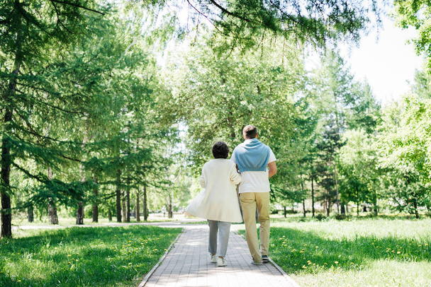 Keski-ikäinen aviopari kävelee puistossa
. - Valokuva, kuva