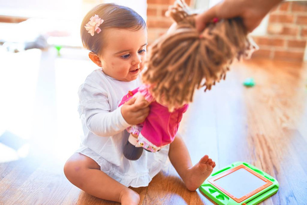 Младенец счастлив вокруг разноцветных игрушек, играющих с долой
 - Фото, изображение