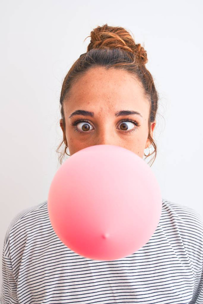 Joven readhead mujer moderna masticando chicle y haciendo burbuja de aire
 - Foto, imagen