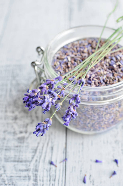 natural lavender flowers and dried lavender buds in a glass jar - Foto, Bild