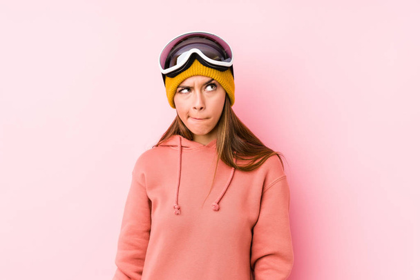 Mujer caucásica joven con una ropa de esquí aislado confundido, se siente dudoso e inseguro
. - Foto, imagen