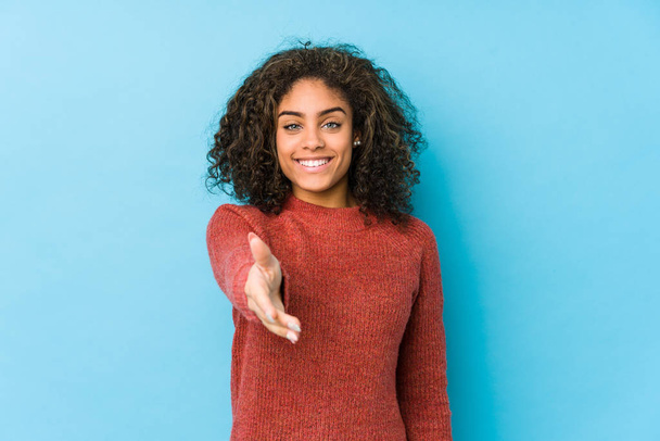 Fiatal afro-amerikai göndör haj nő nyújtja kezét a kamera üdvözlő gesztus. - Fotó, kép