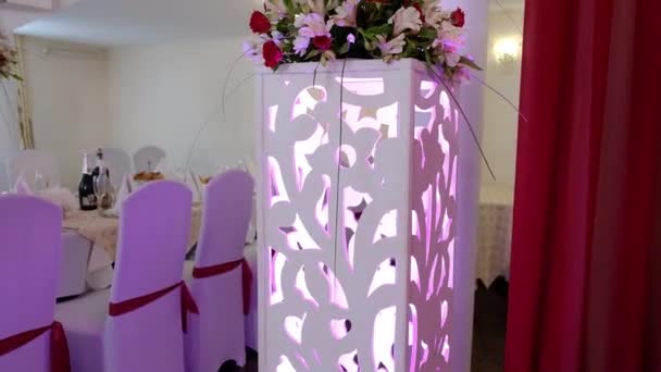 Çiçeklerle süslenmiş düğün salonu. Taze çiçekli bir masa. Ziyafet salonu - Video, Çekim