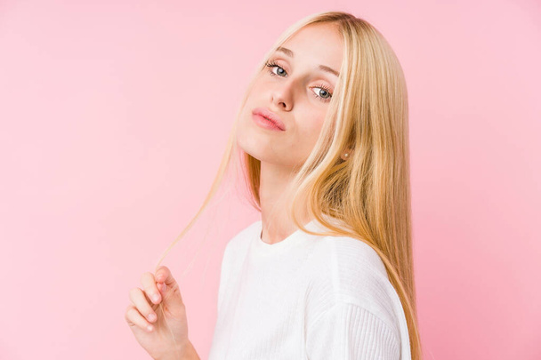 Young blonde woman face closeup isolated on a pink background - Photo, image