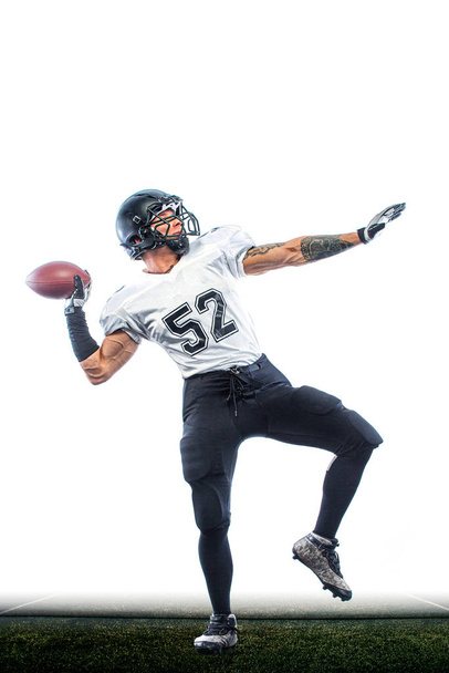 American football player. Sportsman with ball in helmet on stadium in action. Sport wallpaper. Team sports. - Foto, Imagen