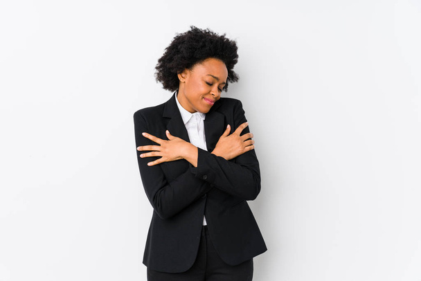 Middle aged african american business  woman against a white background isolated hugs, smiling carefree and happy. - Foto, Imagen