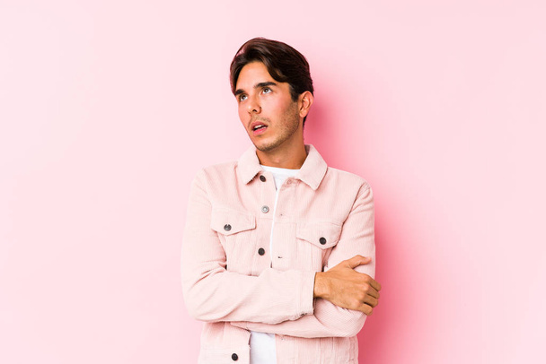 Young caucasian man posing in a pink background isolated tired of a repetitive task. - Photo, Image