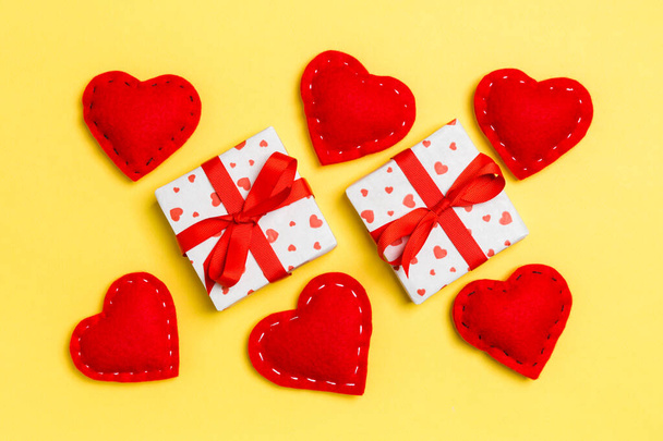 ギフトボックスと赤いテキスタイルの心で作られたカラフルなバレンタインの背景のトップビュー。バレンタインデーのコンセプト - 写真・画像