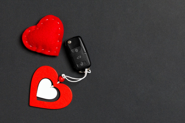 Top view of car key, wooden and textile heart on colorful background. Luxury present for Valentine's day - Photo, Image