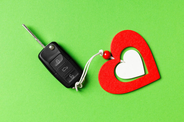 Vue de dessus de la clé de voiture et coeur en bois sur fond coloré. Cadeau de luxe pour la Saint Valentin
 - Photo, image