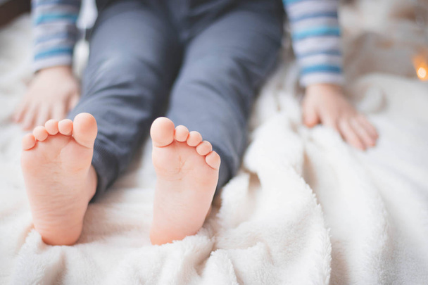 Cozy holidays at home. Close up photo of little child barefooted feet.  Winter season lifestyle. Leisure time. Sweet childhood.  - Photo, Image