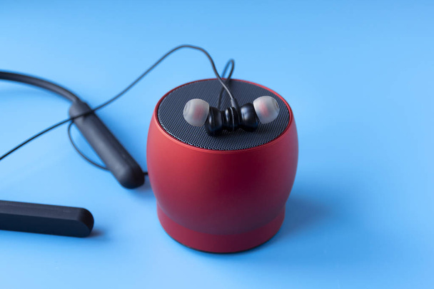 Беспроводные Bluetooth устройства для телефона, черные наушники и красный динамик. Гарнитура для телефона
 - Фото, изображение