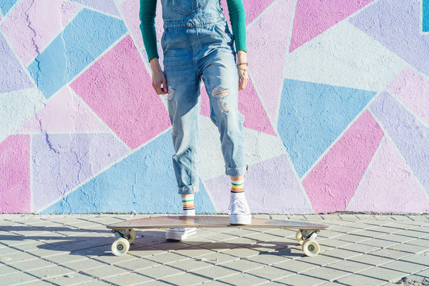 Onherkenbare vrouw met skateboard op straat - Foto, afbeelding
