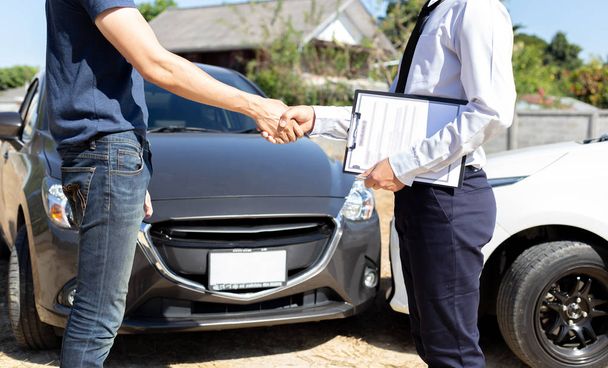Kunden schütteln Autoversicherungsvertretern die Hand, um freundliche Bedingungen zu vereinbaren, Autounfall auf der Straße. - Foto, Bild