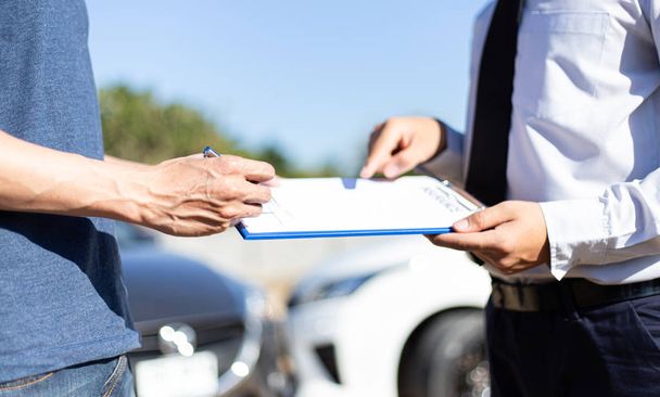 Kunden und Kfz-Versicherungsvertreter haben Vereinbarungen getroffen und Dokumente unterzeichnet, um Schadensersatz nach einem Autounfall zu fordern, Versicherungskonzept. - Foto, Bild